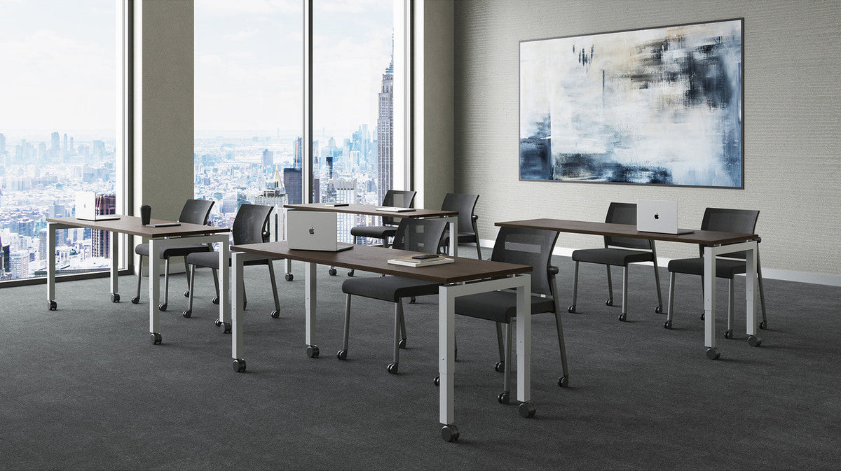 Four OfficeSource modern training tables with adjustable height legs and locking casters in a training seminar room